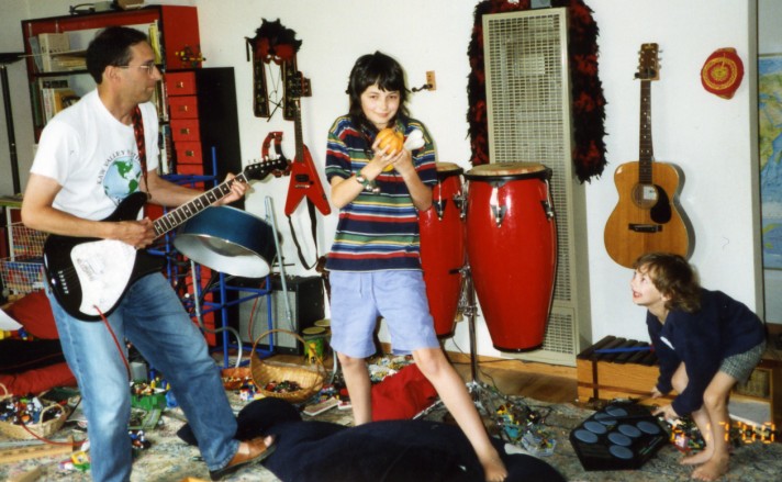 a June 2000 photo of Peter playing my Fender Venus, my son Sam playing a pumpkin shaker, a bone shaker and some bells, and my son Arthur playing electronic drums